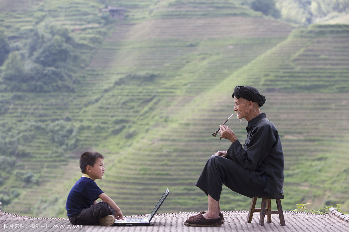 高级男子男孩(5-7)使用笔记本电脑户外,侧面查看
